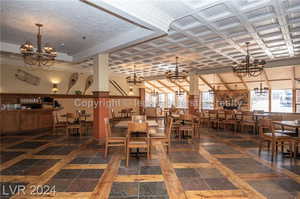 Dining area with dark tile patterned flooring and a notable chandelier