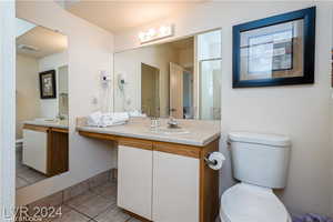 Bathroom featuring tile patterned flooring, a shower with door, toilet, and vanity