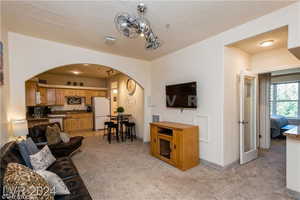 Carpeted living room with a textured ceiling