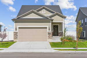 Craftsman inspired home with a front lawn and a garage