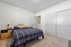 Bedroom with a closet and light carpet