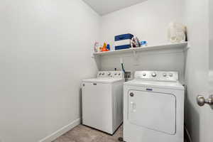 Washroom featuring light tile patterned floors and separate washer and dryer