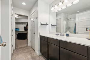 Bathroom with tile patterned flooring, a shower with shower door, and vanity