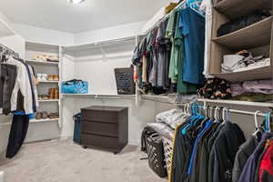 Walk in closet with light colored carpet