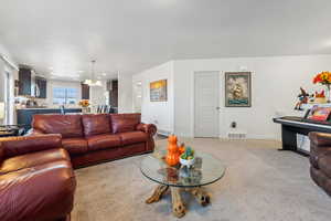 Living room with a notable chandelier and carpet flooring