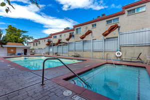 View of swimming pool featuring a hot tub