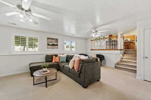 Carpeted living room with ceiling fan