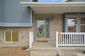 View of exterior entry with a porch