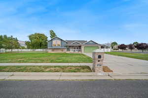 View of front of property with a garage and a front lawn