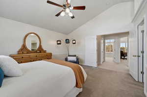 Bedroom featuring ceiling fan, high vaulted ceiling, and light carpet