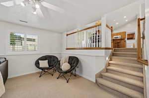 Sitting room featuring ceiling fan, light carpet, and lofted ceiling