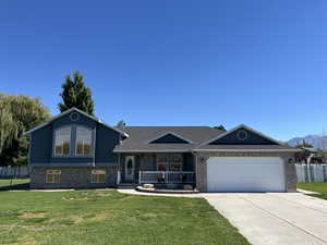 Tri-level home featuring a front lawn and a garage