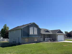 Split level home featuring a garage and a front lawn