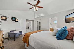 Bedroom with ceiling fan, carpet, vaulted ceiling, and ensuite bath