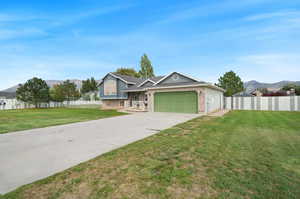 View of front of home featuring a front yard and a garage