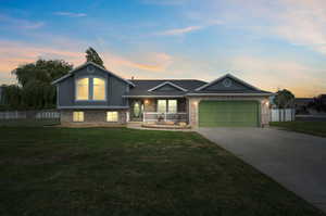 View of front of property with a yard and a garage