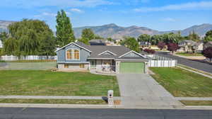 View of front of house featuring a garage, a mountain view, and a front yard