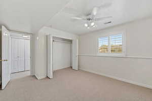 Unfurnished bedroom with ceiling fan and light carpet