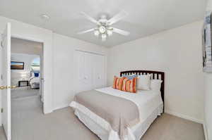 Carpeted bedroom featuring a closet and ceiling fan