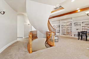 Interior space featuring light carpet and beam ceiling