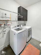 Clothes washing area featuring water heater and washer and clothes dryer