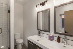 Bathroom with an enclosed shower, toilet, and vanity