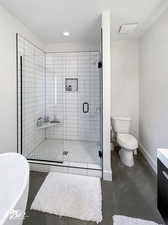 Full bathroom with concrete flooring, separate shower and tub, vanity, and toilet