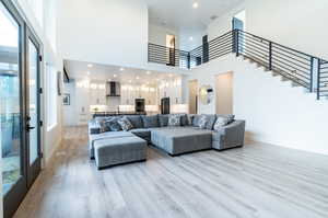 Living room featuring light hardwood / wood-style floors, a towering ceiling, and plenty of natural light