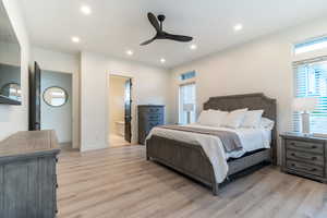 Bedroom with ceiling fan, ensuite bathroom, and light hardwood / wood-style floors