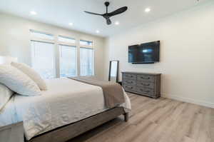 Master suite featuring ceiling fan and light hardwood / wood-style flooring