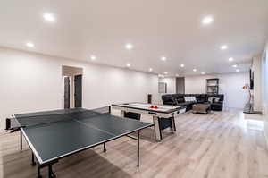 Game room with light hardwood / wood-style flooring