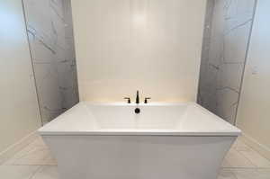 If you like baths this tub is waiting for you! Bathroom featuring tile patterned flooring and a bath