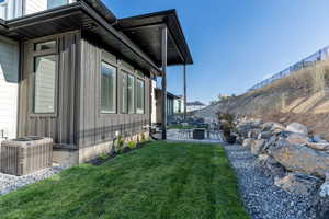 View of property exterior with a patio, central air condition unit, and a yard