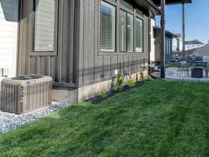 View of property exterior with a patio, central air condition unit, and a yard