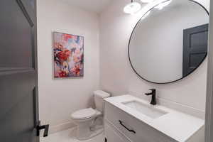 Bathroom with tile patterned flooring, vanity, and toilet