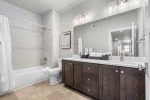 Full bathroom with shower / bath combination with curtain, toilet, tile patterned flooring, and vanity