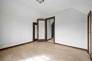 Empty room featuring light hardwood / wood-style floors and lofted ceiling