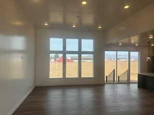 Empty room with a mountain view and dark wood-type flooring