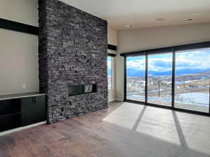 Master Bedroom featuring a fireplace, walnut hardwood floors, and lofted ceiling showing steel beams.