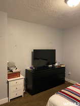 Carpeted bedroom featuring a textured ceiling