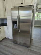 Kitchen featuring hardwood / wood-style flooring, ceiling fan, and stainless steel refrigerator with ice dispenser