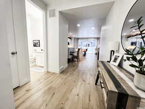 Spacious well lit entryway with natural light from the front door to the sliding back doors, and entry to the 1st floor bathroom and the office/guest bedroom.