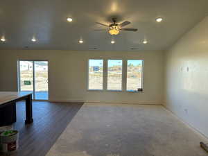 Unfurnished room featuring ceiling fan, wood-type flooring, and plenty of natural light