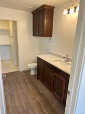 Bathroom featuring toilet, vanity, and wood-type flooring