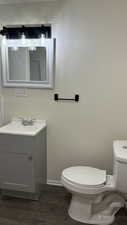 Bathroom with toilet, vanity, and hardwood / wood-style flooring