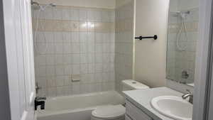 Full bathroom featuring toilet, vanity, and tiled shower / bath