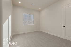 Unfurnished room featuring light carpet