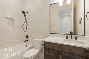 Full bathroom featuring toilet, vanity, and tiled shower / bath