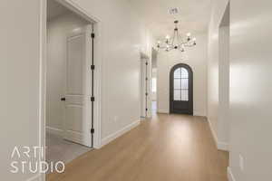 Entryway with a notable chandelier and light hardwood / wood-style flooring