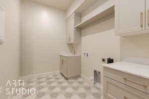 Clothes washing area featuring cabinets, sink, washer hookup, and hookup for an electric dryer